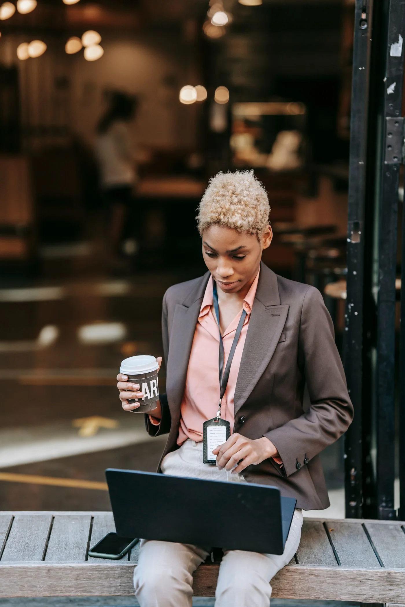 A businesswoman working on her laptop outside a café